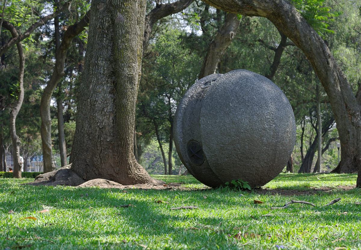 A glowing spherical garden lamp at dusk